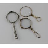 Two pairs of folding lorgnettes and a magnifying glass