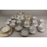 A matched Victorian porcelain part tea service, with scrolling grey and gilt decoration on white