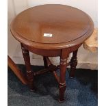 A small oak side table with circular top on baluster turned legs with uniting X frame stretcher