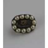 A small seed pearl mounted mourning brooch, monogrammed 'EB' inset with a plait of hair, inscription