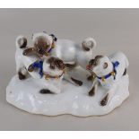 A Meissen porcelain group of three pug dogs the base incised F186 and with blue crossed swords
