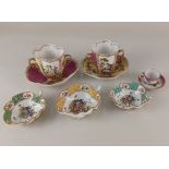 A collection of Augustus Rex style porcelain comprising two chocolate cups and saucers of lobed