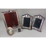 A pair of modern silver photograph frames rectangular apertures with arched scroll borders on blue