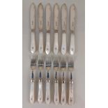 A set of six pairs of George V silver fish knives and forks with mother of pearl handles with