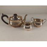 A George V silver three piece bachelor tea service of teapot, sugar bowl and cream jug, maker