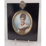 A 19th century oval miniature portrait of a lady wearing coral jewellery, indistinctly signed, on i