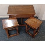 An oak nest of three occasional tables comprising of a rectangular table and two smaller on block