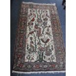 An Eastern rug decorated with birds amongst flowers within multiple borders, cream ground, 136cm