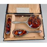 A cased silver plated and faux tortoiseshell four-piece dressing table set of two brushes, comb