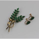A gold and jade brooch designed as a spray detailed '14k', with a pair of gold and jade single stone