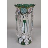 A Bohemian white overlaid green glass table lustre, with crenellated top decorated with oval