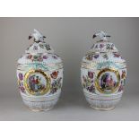 A pair of Berlin style porcelain vases and covers, each of ribbed ovoid form decorated with laurel