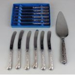A set of six George V silver handled dessert knives pistol grip handles cast with flowers and