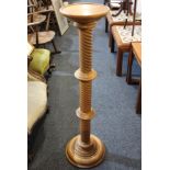 A light oak jardiniere stand with circular top on spiral turned support, 101cm