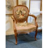 A French style tapestry upholstered elbow chair with oval panelled back, serpentine seat and
