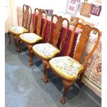 A set of four Queen Anne style walnut dining chairs shell carved splats and drop in tapestry seats
