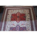 A Persian rug with three lozenge design centre and cream ground with allover pattern of geometric