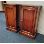 A pair of mahogany bedside cupboards with panelled doors on plinth bases, width 40cm height 73cm