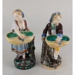 A pair of 19th century Minton majolica figures modelled as a girl and boy holding oval baskets and