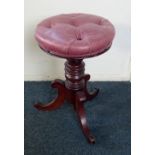 A reproduction Victorian style piano stool with circular button upholstered adjustable seat on