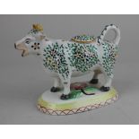 A Staffordshire pottery floral decorated cow creamer 13cm high