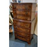 A reproduction walnut small bowfront chest on chest with seven drawers, on bracket feet, width