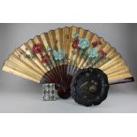 A Chinese floral and gilt card fan 58cm, a black painted metal plate hand painted with a bird and