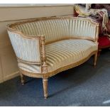 A French style giltwood framed salon settee with C shaped striped upholstered back and seat,