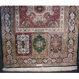 A Persian rug finely woven with multiply floral panels, signed, 150cm by 100cm