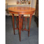 An Edwardian mahogany circular occasional table on tapered legs with spade feet and fretwork cross