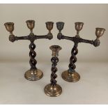 A pair and single Medieval style silver mounted oak candlesticks comprising two candlesticks with