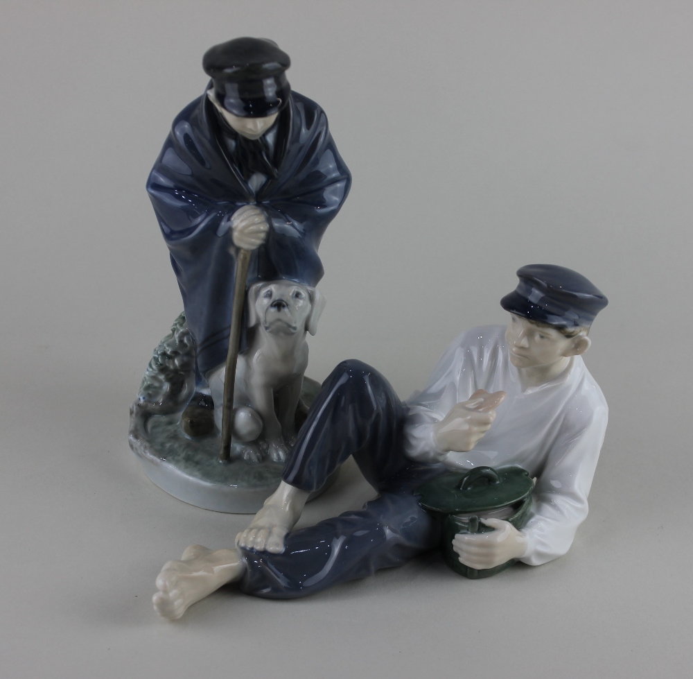 Two Royal Copenhagen porcelain figures of a boy with a dog and another of a reclining youth, 19cm