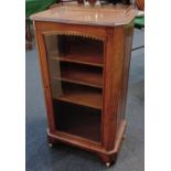 A Victorian walnut music cabinet with brass gallery, single glazed door enclosing three shelves,