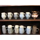 Eleven 20th century studio pottery glazed mugs and tankards all by the same hand, with patterned
