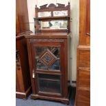 A Victorian mahogany music cabinet with raised mirrored back and broken arch pediment, above