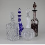 A cranberry glass decanter a blue flash cut decanter and two other clear cut glass decanters, all