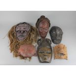 Tribal / ethnographic interest, six various masks, together with a carved wood plaque