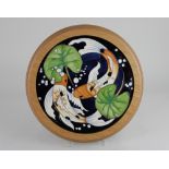 A framed Moorcroft pottery 'Singapore' circular plaque, decorated with a pair of carp 26cm diameter
