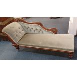 A Victorian button back upholstered chaise longue, with floral carved and pierced frame on turned