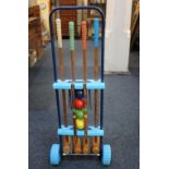 A child's croquet set with frame set on wheels, to include four mallets, four balls, two pegs and
