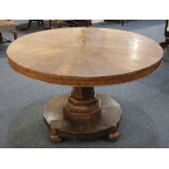 A Victorian walnut circular table with segmental veneered top on facetted pedestal support and