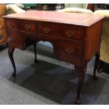 A reproduction mahogany kneehole desk with rectangular red tooled leather top above four drawers