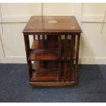A reproduction inlaid mahogany revolving bookstand with slatted side on swivel base and castors,