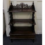 A Victorian style mahogany whatnot with three shaped tiers, pieced supports with drop finials,