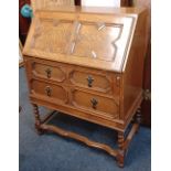 A Jacobean style oak bureau geometric panelled fall front enclosing pigeon hole and small drawer