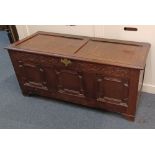 A carved oak coffer with three geometric panelled front, on bracket feet, 129cm