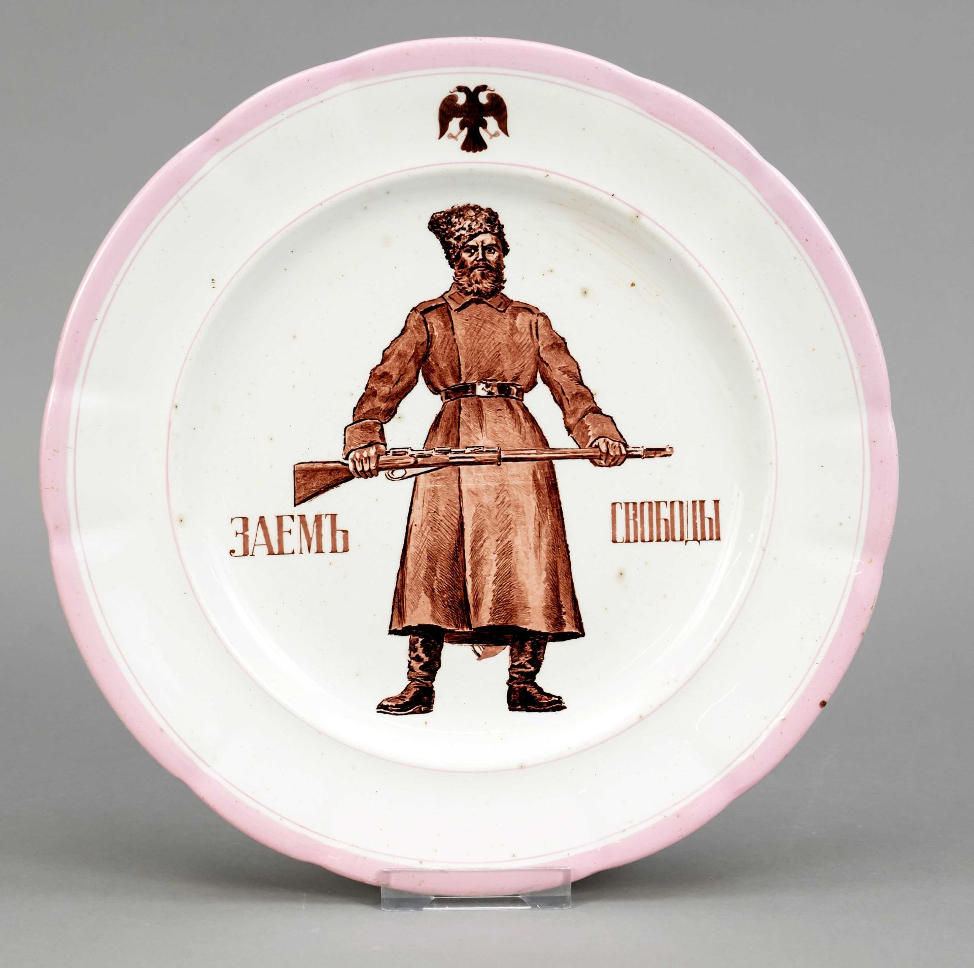 Plate, Kuznetzov manufactory, early 20th century, in the mirror Russian Cossack with a rifle between