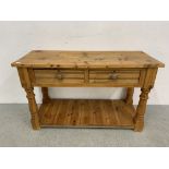 A SOLID WAXED PINE TWO DRAWER SIDE TABLE WITH HEAVY TURNED SUPPORTS - W 127CM. D 50CM. H 77CM.