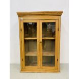 AN ANTIQUE WAXED PINE TWO DOOR GLAZED CABINET WITH SHELVED INTERIOR - W 78CM. D 30CM.H 112CM.