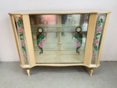 A 1950'S DISPLAY CABINET WITH ROSE DECORATION TO SLIDING DOORS AND SIDE PANELS - W 122CM. D 35CM.